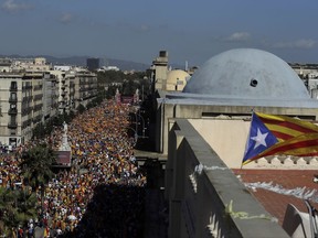 A ''estelada'' or Catalonia independence flag flies on the roof of of a building as thousands march in downtown Barcelona, Spain, to protest the Catalan government's push for secession from the rest of Spain, Sunday Oct. 8, 2017. Sunday's rally comes a week after separatist leaders of the Catalan government held a referendum on secession that Spain's top court had suspended and the Spanish government said was illegal. (AP Photo/Manu Fernandez)