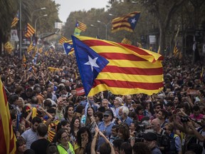 People wave "estelada" or pro independence flags in Barcelona, Spain, after Catalonia's regional parliament passed a motion with which they say they are establishing an independent Catalan Republic, Friday, Oct. 27, 2017. (AP Photo/Santi Palacios)