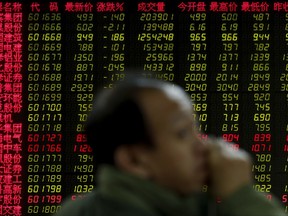 A man looks back as he monitors stock prices at a brokerage house in Beijing, Monday, Oct. 30, 2017.  Asian stock markets were mixed Monday as investors waited to find out who U.S. President Donald Trump will pick to head the Federal Reserve. (AP Photo/Andy Wong)