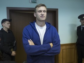 Russian opposition leader Alexei Navalny, right, meets to the media during a break in the hearing on his appeal in a court in Moscow, Russia, Friday, Oct. 6, 2017. Navalny, arguably Russia's most popular opposition politician, has declared his intention to run and inspired  grassroots campaign to support his nomination for president. (AP Photo/Pavel Golovkin)