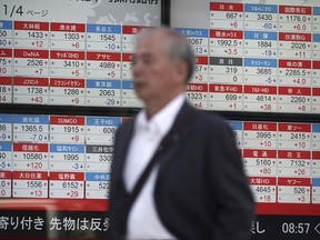 A man walks past an electronic stock board showing Japan's Nikkei 225 index at a securities firm in Tokyo Wednesday, Oct. 18, 2017. Asian shares were mixed on Wednesday, as some indexes got a boost from overnight gains on Wall Street. Japan's benchmark held steady as expectations grew that a likely ruling party win in Sunday's Japanese parliamentary elections will help stability and growth.(AP Photo/Eugene Hoshiko)
