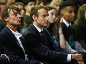 French President Emmanuel Macron, center, and Environment Minister Nicolas Hulot, left, listen to speeches during a meeting at Rungis international food market, near Paris, Wednesday, Oct.11, 2017. President Macron details his proposals to help French farmers being more competitive and get fair pay for their work. (AP Photo/Francois Mori , Pool)