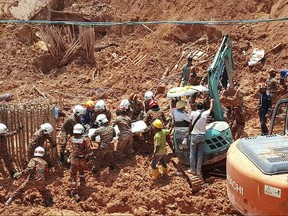 Malaysian rescuers carry the body of a victim after he was pulled out from the debris of the landslide in Penang, Malaysia, Sunday, Oct. 22, 2017. A landslide at a construction site in northern Malaysia on Saturday killed a number of foreign workers, with rescuers searching for others feared trapped in the mud and rubble, officials said. Fire and rescue official Mohamad Rizuan Ramli said a 10 meter (33 feet) high slope crashed down at the construction site in northern Penang state, a popular tourist destination, early Saturday. (AP Photo/Gary Chuah)