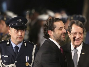 Lebanese Prime Minister Saad Hariri, center, and Cyprus President Nicos Anastasiades smile after they review a military guard of honor during the welcoming ceremony before a meeting at the presidential palace in Nicosia, Cyprus, on Saturday, Oct. 28, 2017.  Hariri is in Cyprus for one-day official talks visit. (AP Photo/Petros Karadjias)
