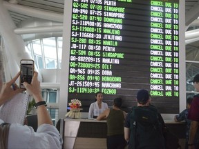 A flight information board shows cancelled flights at Ngurah Rai International Airport in Denpasar, Bali, Indonesia, Tuesday, Nov. 28, 2017. Mount Agung volcano on Bali has erupted for the first time in more than half a century, forcing closure of the Indonesian tourist island's busy airport as the mountain gushes huge columns of ash that are a threat to airplanes. (AP Photo/Ketut Nataan)