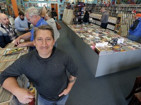 In this Wednesday, Nov. 8, 2017, photo, John Dudas, owner of Carol and John's Comic Book Shop, poses during New Comic Day in Cleveland. Some smaller retailers will tug at shoppers' heartstrings during the holidays, trying to create an emotional experience or connection that a big national chain might not provide. Dudas recently participated in Local Comic Shop Day, which he calls the comic book industry's equivalent of Black Friday. People lined up outside his store for limited-edition comics, and had a great time while they waited. (AP Photo/Tony Dejak)