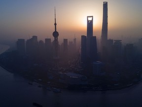 The sun rises behind the skyline of Pudong's Lujiazui Financial District in Shanghai.