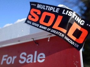 A real estate sold sign is shown outside a house in Vancouver.