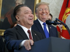 President Donald Trump smiles at Broadcom CEO Hock Tan during an event to announce that the company is moving its global headquarters to the United States, in the Oval Office of the White House, Thursday, Nov. 2, 2017, in Washington.