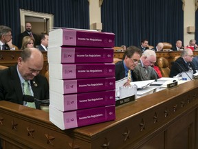 Volumes of tax regulations are stacked on the dais as the House Ways and Means Committee begins the markup process of the GOP's far-reaching tax overhaul, the first major revamp of the tax system in three decades, on Capitol Hill in Washington, Monday, Nov. 6, 2017. (AP Photo/J. Scott Applewhite)