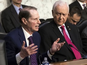 Sen. Ron Wyden, D-Ore., left, the top Democrat on the Senate Finance Committee, criticizes the Republican tax reform plan while Chairman Orrin Hatch, R-Utah, listens to his opening statement as the panel begins work overhauling the nation's tax code, on Capitol Hill in Washington, Monday, Nov. 13, 2017. The legislation in the House and Senate carries high political stakes for President Donald Trump and Republican leaders in Congress, who view passage of tax cuts as critical to the GOP's success at the polls next year. (AP Photo/J. Scott Applewhite)
