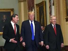 President Donald Trump, center, walks with Sen. John Barrasso, R-Wyo., left, and Senate Majority Leader Mitch McConnell of Ky., right, as he arrives on Capitol Hill in Washington, Tuesday, Nov. 28, 2017. (AP Photo/Susan Walsh)
