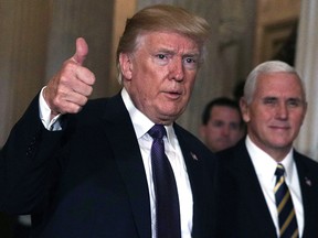 Accompanied by Vice President Mike Pence, right, U.S. President Donald Trump leaves the Capitol after he attended a House Republican Conference meeting on the tax reform bill.