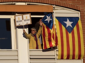 People react on a balcony as demonstrators take part at a protest calling for the release of Catalan jailed politicians, in Barcelona, Spain, on Saturday, Nov 11, 2017. Eight members of the now-defunct Catalan government remain jailed in a related rebellion case. Former regional president Carles Puigdemont and four other ex-cabinet members fled to Belgium where they are fighting extradition. (AP Photo/Emilio Morenatti)