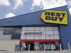 In this Monday, May 22, 2017, photo, people walk out of a Best Buy store after purchasing an LED TV, in Hialeah, Fla. Best Buy Co. Inc. reports earnings Thursday, Nov. 16, 2017. (AP Photo/Alan Diaz)