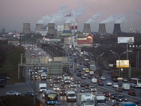 FILE - In this Nov. 8, 2017 file photo traffic crowds a road in Moscow, Russia after a sunset as smoke billows from a power plant in background. The COP 23 Fiji UN Climate Change Conference in Bonn, Germany, is scheduled to end Friday, Nov. 17 and aims at producing draft rules for implementing the Paris accord. . (AP Photo/Pavel Glolovkin, file)