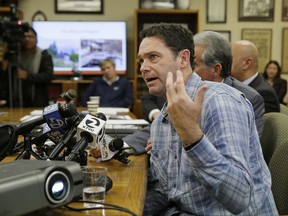 Gregory Wilson, who lost his Santa Rosa home and most of his voice during last month's wildfires, tries to speak during a news conference Tuesday, Nov. 14, 2017, in Burlingame, Calif. Attorneys have filed a series of lawsuits against PG&E Corporation and Pacific Gas & Electric Company on behalf of victims of the North Bay fires. Filed in San Francisco Superior Court on Tuesday, the plaintiffs include former San Francisco Mayor Frank Jordan and his wife who fled the fire and lost their Santa Rosa home, and Gregory and Christina Wilson who sought refuge in their swimming pool in an effort to avoid being burned by the fire. (AP Photo/Eric Risberg)