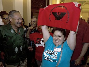 FILE -- In this Aug. 29, 2016 file photo Maria Ceja, right, joined other farm workers in celebrating outside the Assembly Chambers after lawmakers approved a measure requiring farmworkers to receive overtime pay after working eight hours, at the Capitol, in Sacramento, Calif. In a unanimous ruling Monday, Nov. 27, 2017, the high court in California upheld a law that aims to get labor contracts for farmworkers whose unions and employers do not agree on wages and other working conditions. (AP Photo/Rich Pedroncelli, File)