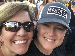 In this Oct. 1, 2017 photo provided by Chris Gilman, Gilman, right, is pictured in a selfie with her wife, Aliza Correa, before being shot in the Las Vegas massacre that killed dozens of people and wounded hundreds of others at the Route 91 Harvest festival. Gilman of Bonney Lake, Wash., was rescued by two strangers after suffering a gunshot wound at the concert. Gilman posted to the site "Find My LV Hero," and discovered that her rescuers were two off-duty Los Angeles County sheriff's deputies. (Courtesy of Chris Gilman via AP)