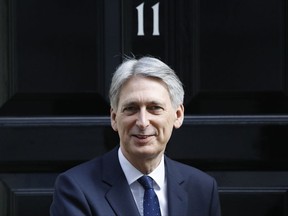 FILE - In this Thursday, March 16, 2017 file photo, Britain's Chancellor Philip Hammond walks out of 11 Downing Street in London. Britain's Treasury chief is likely to ignore demands that the government ease seven years of austerity when he unveils the budget Wednesday Nov. 22, 2017, opting instead to keep a tight rein on spending as economic growth slows and the country prepares for the impact of Brexit. (AP Photo/Frank Augstein, File)