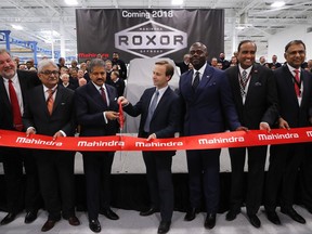 Mahindra Group Chairman Anand G. Mahindra, third from left, participates with Michigan Lt. Gov. Brian Calley, fourth from left, in a ceremonial ribbon butting in Auburn Hills, Mich., Monday, Nov. 20, 2017. Indian conglomerate Mahindra Group is opening an automotive manufacturing facility near Detroit. Mahindra says it will make an off-road vehicle at the 400,000-square-foot plant in Auburn Hills. (AP Photo/Paul Sancya)