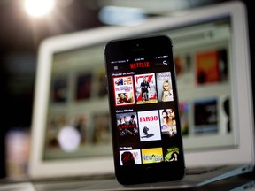 The Netflix app is displayed on an Apple iPhone