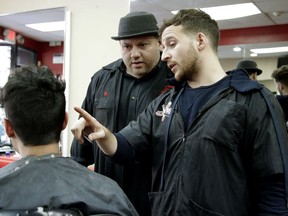Carlos Echeverry, center, owner of Fabulous Stylz in Rutherford, N.J., talks to employee James Dutch, right, as they discuss a customer's haircut, Friday, Nov. 3, 2017, in Rutherford, N.J. Echeverry, a home owner, said his property taxes continue to rise and has yet to see any exemptions kick in but wouldn't mind if they stayed at about $8,000, which he currently pays. (AP Photo/Julio Cortez)