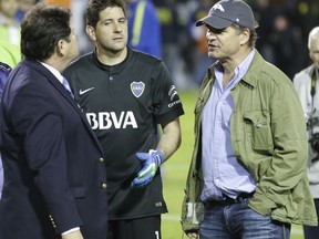 FILE - In this May 14, 2015, file photo, CONMEBOL delegate Roger Bello, of Bolivia, left, talks with Boca Juniors goalkeeper Agustin Orion, center, and Alejandro Burzaco, president of Torneos y Competencias, during a Copa Libertadores soccer match between Boca Juniors and River Plate, in Buenos Aires, Argentina. Burzaco, the former CEO of a marketing firm based in Argentina, testified Tuesday, Nov. 14, 2017, at the U.S. trial of three former South American soccer officials accused of taking bribes in a sprawling corruption investigation of FIFA,  that Fox was among several media companies paying bribes through sham contracts for the Copa America and other events. (AP Photo/Victor R. Caivano, File)