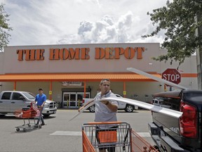 FILE - In this Monday, July 13, 2015, file photo, Vicente Aguiar loads garage door trims into his pickup truck outside The Home Depot in Hialeah, Fla. The Home Depot Inc. reports financial results on Tuesday, Nov. 14, 2017. (AP Photo/Alan Diaz, File)