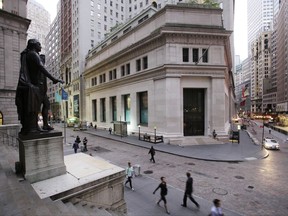 FILE - In this Oct. 8, 2014, file photo, people walk to work on Wall Street beneath a statue of George Washington, in New York. U.S. stocks are opening higher Tuesday, Nov. 21, 2017, as most industries, including technology and health care companies, start the day with solid gains. (AP Photo/Mark Lennihan, File)