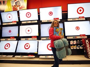 FILE - In this Nov. 28, 2014, file photo, a customer walks past a bank of flat screen televisions at a Target store in South Portland, Maine. Target Corp. reports earnings Wednesday, Nov. 15, 2017. (AP Photo/Robert F. Bukaty, File)