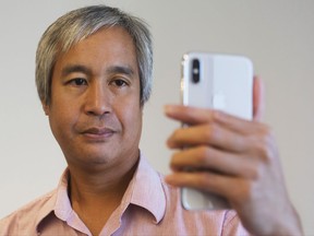 In this Monday Oct. 30, 2017, photo, Associated Press reporter Anick Jesdanun demonstrates Face ID, Apple's name for its facial-recognition technology, on an iPhone X in New York. (AP Photo/Mark Lennihan)