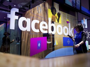 FILE - In this Tuesday, April 18, 2017, file photo, a conference worker passes a demo booth at Facebook's annual F8 developer conference in San Jose, Calif. Facebook Inc. reports earnings Wednesday, Nov. 1, 2017. (AP Photo/Noah Berger, File)
