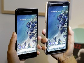 FILE - In this Wednesday, Oct. 4, 2017, file photo, a woman holds up the Google Pixel 2 phone, left, next to the Pixel 2 XL phone at a Google event at the SFJAZZ Center in San Francisco. Google prides itself on the intelligence of its search engine and other services, but it's discovering that even companies brimming with brainpower face a tough learning curve when venturing into new markets. The hard lessons are coming in hardware as Google rolls out a new wave of Pixel smartphones and speakers that have suffered some early problems. (AP Photo/Jeff Chiu, File)