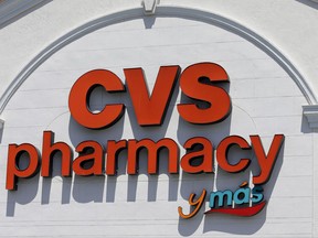 FILE- In this May 15, 2017, photo, shows a CVS pharmacy sign at a store in Hialeah, Fla. Drugstore chain CVS and online travel website Priceline are among the many companies reporting quarterly earnings this week. The Labor Department releases data on the number of job openings in September on Tuesday, Nov. 5  (AP Photo/Alan Diaz, File)
