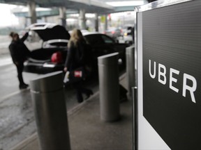 FILE - In this March 15, 2017, file photo, a sign marks a pick-up point for the Uber car service at LaGuardia Airport in New York. Uber is coming clean about its cover-up of a year-old hacking attack that stole personal information about more than 57 million of the beleaguered ride-hailing service's customers and drivers. The revelation Tuesday marks the latest stain on Uber's reputation. (AP Photo/Seth Wenig, File)