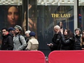 Visitors to Christie's wait outside in a line to view Leonardo da Vinci's "Salvator Mundi", Tuesday, Nov. 14, 2017, in New York. The painting is expected to sell at auction for $100 million on Wednesday. (AP Photo/Julie Jacobson)