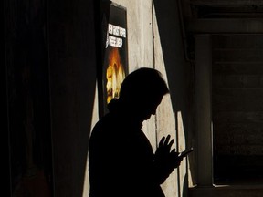 FILE - In this Oct. 12, 2016, file photo, a morning commuter uses his smartphone on the platform of the Long Island Rail Road at the Bayside Station in the Queens borough of New York. New York City, Los Angeles, Chicago and Las Vegas are among scores of police departments across the country quietly using a highly secretive technology developed for the military that can track the whereabouts of suspects by using the signals constantly emitted by their cellphones. Civil liberties and privacy groups are increasingly raising objections to the suitcase-sized devices known as StingRays or cell site simulators that can sweep up cellphone data from an entire neighborhood by mimicking cell towers. (AP Photo/Alexander F. Yuan, File)