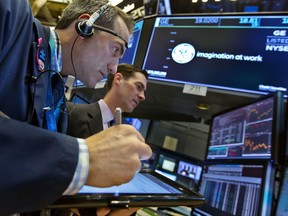 Trader Gregory Rowe, left, and specialist John McNierney work at the post that handles General Electric on the floor of the New York Stock Exchange, Tuesday, Nov. 14, 2017. Stocks are opening lower on Wall Street as technology companies, banks and retailers sink. (AP Photo/Richard Drew)