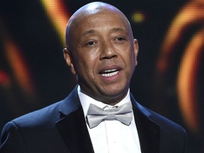 FILE - In this Feb. 6, 2015, file photo, hip-hop mogul Russell Simmons presents the Vanguard Award on stage at the 46th NAACP Image Awards in Pasadena, Calif. Simmons announced on Nov. 30, 2017, he would be stepping down from companies he founded following a new allegation of sexual misconduct. (Photo by Chris Pizzello/Invision/AP, File)