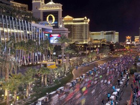 FILE - In this Dec. 4, 2011 file photo, runners stream southward on Las Vegas Boulevard during the Rock 'n Roll Las Vegas Marathon in Las Vegas. More than 40,000 people will run on Sunday, Nov. 12, 2017, under the watchful eyes of snipers and surrounded by other law-enforcement safety measures during the Las Vegas Rock 'n' Roll Marathon, the first large-scale outdoor event the city's hosting since a gunman killed 58 people gathered at a country music festival last month. (AP Photo/Julie Jacobson, File)