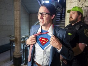 Prime Minister Justin Trudeau shows off his costume as Clark Kent, alter ego of comic book superhero Superman, as he walks through the House of Commons, in Ottawa on Tuesday, October 31, 2017.