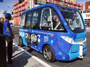 Patrons wait to board a driverless shuttle bus on a street in Las Vegas, Wednesday, Nov. 8, 2017. Earlier Wednesday one of the buses was involved in a collision less than two hours after the service was launched. Police say no injuries were reported in the Wednesday crash between the self-operating vehicle and a semi-truck. It's not yet clear what caused the wreck. (AP Photo/Regina Garcia Cano)