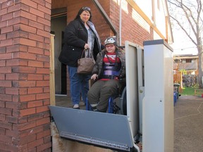 In this Nov. 21, 2017 photo, Jodi Dean helps her wheelchair-bound daughter Madison, who suffers epilepsy and severe osteoporosis, on an elevator as they leave home for a doctor's visit in Hamilton, Ontario, Canada. The mother of three received her first basic income check last month and said the extra money gave her family "the breathing room to not have to stress to put food on the table." (AP Photo/Rob Gillies)