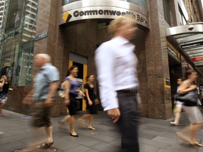 FILE - In this Feb. 9, 2011, file photo, people walk past a Commonwealth Bank branch in Sydney, Australia. The Australian government bowed to growing pressure on Thursday, Nov. 30, 2017 by announcing a high-level inquiry into misbehavior in Australia's financial sector. (AP Photo/Rick Rycroft)