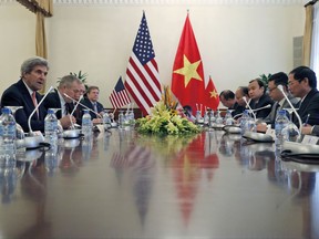 FILE - In this Jan. 13, 2017, file photo, Vietnamese Deputy Foreign Minister Bui Thanh Son, right, listens to then U.S. Secretary of State John Kerry, left, during a meeting at Ministry of Foreign Affairs in Hanoi, Vietnam. Vietnam is hoping leaders of the remaining 11-member countries of a Pacific Rim trade pact, the Trans-Pacific Partnership, may be able to discuss a revised deal following the U.S.'s withdrawal, Son said Thursday, Nov. 2, 2017. (AP Photo/Alex Brandon, Pool, File)