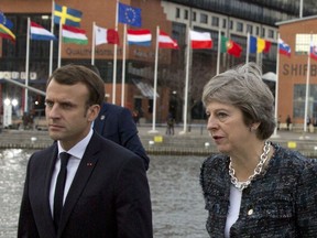 FILE - In this Nov. 17, 2017 file photo, British Prime Minister Theresa May, right, speaks with French President Emmanuel Macron as they walk on a pier at an EU summit in Goteborg, Sweden. German chancellor Angela Merkel returns to the European Union summit scene on Friday Nov. 24, 2017 after missing the last one because she showed a rare domestic flaw by struggling to form a coalition. (AP Photo/Virginia Mayo, File)