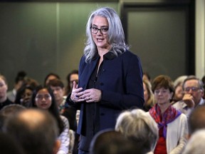 In this photo taken Tuesday, Oct. 24, 2017, Seattle mayoral candidate Cary Moon walks past audience members as she answers a question during a televised debate in Seattle. After 91 years Seattle will elect its second female mayor next week. Voters will choose urban planner Moon or former U.S. attorney Jenny Durkan to lead this city dealing with the benefits and headaches of a booming economy for some more than others as e-commerce giant Amazon expands. (AP Photo/Elaine Thompson)