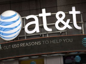 FILE - In this Monday, Oct. 24, 2016, file photo, the AT&T logo is positioned above one of its retail stores in New York. The Justice Department intends to sue AT&T to stop its $85 billion purchase of Time Warner, according to a person familiar with the matter who was not authorized to discuss the suit ahead of its official filing. (AP Photo/Mark Lennihan, File)