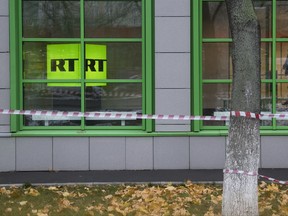 FILE - In this Oct. 27, 2017, file photo, Russian state-owned television station RT logo is seen at the window of the company's office in Moscow, Russia. Russian state-funded TV channel RT has registered with the Justice Department as a foreign agent after pressure from the U.S. government, documents released Nov. 13, 2017, show. (AP Photo/Pavel Golovkin, File)